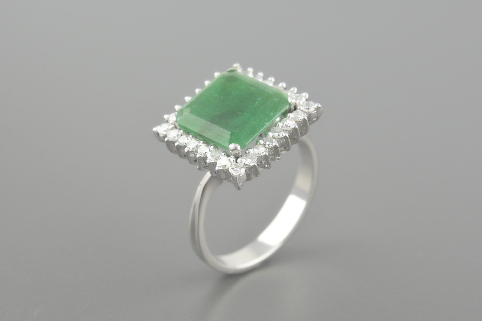 Anel em Ouro Branco 18k com Esmeralda de 11mm e Aprox. 42pts de Brilhantes