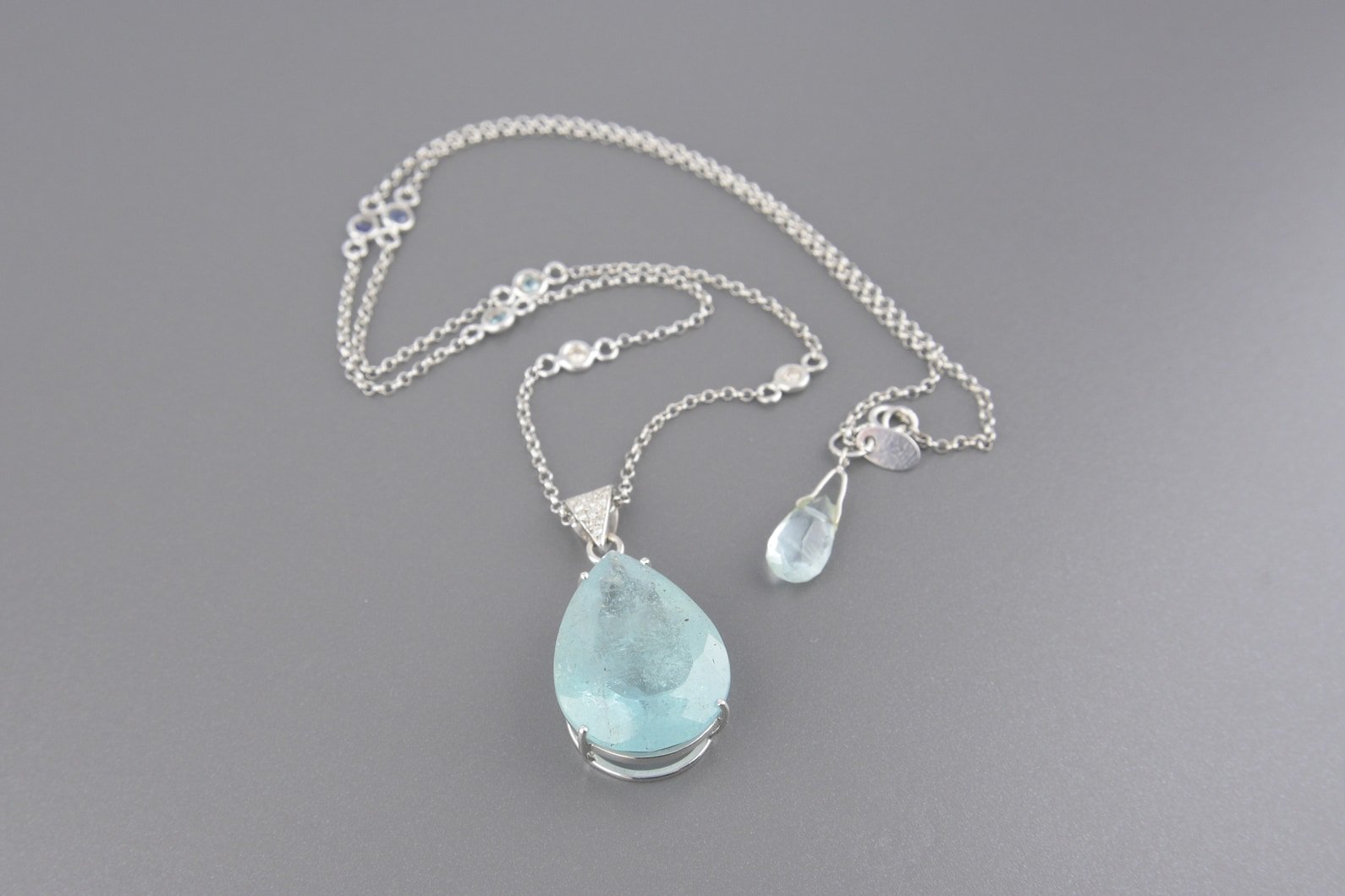 Colar em Ouro Branco 18k com Água Marinha Lap. Gota de 1.68x2.30 cm, Brilhantes, Água Marinha e Safiras.