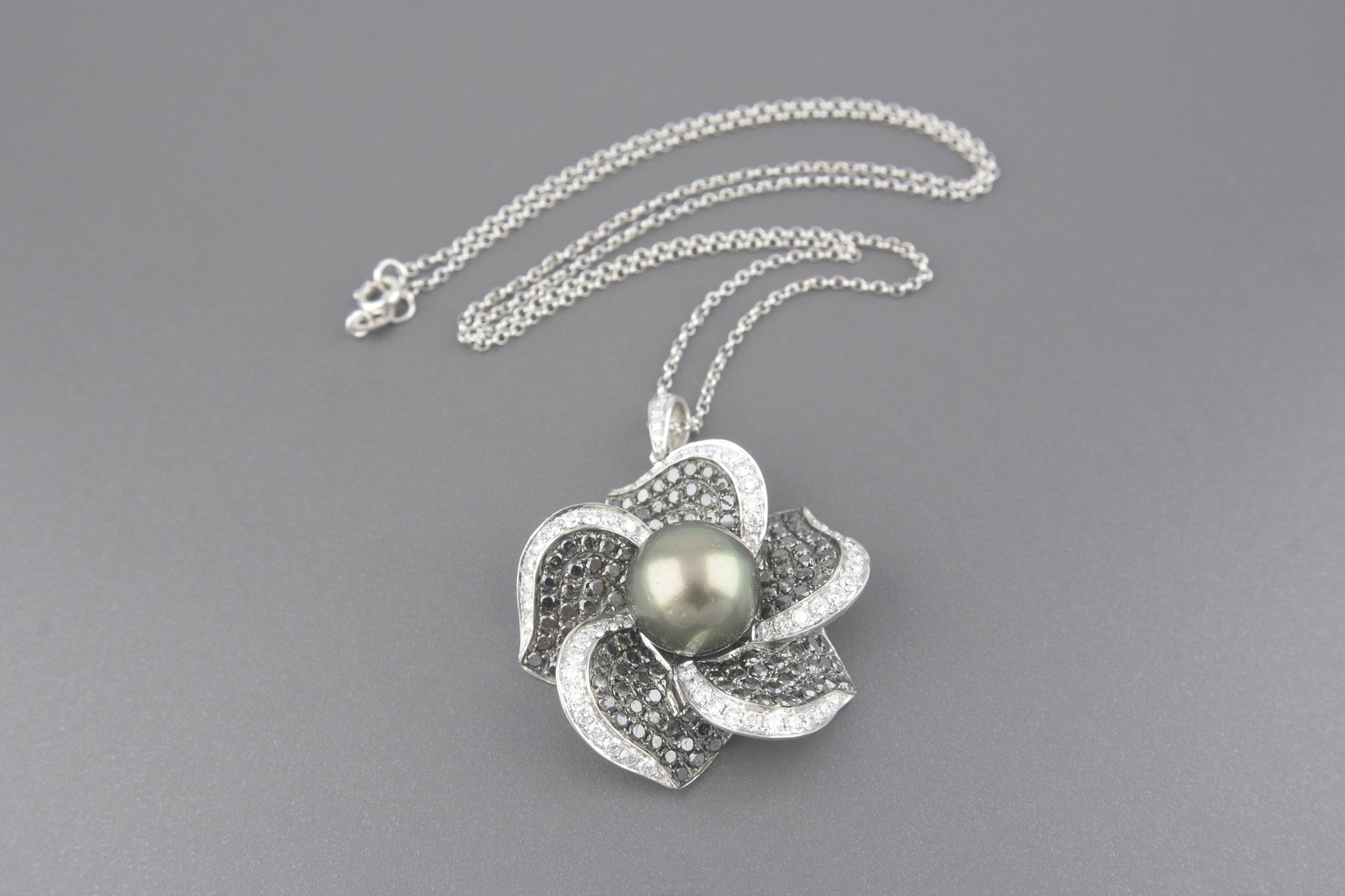 Colar Flor em Ouro Branco 18k com Pérola Negra de 12mm e Aprox. 95pts de Diamantes Brancos e Aprox. 2.10cts de Diamantes Negros