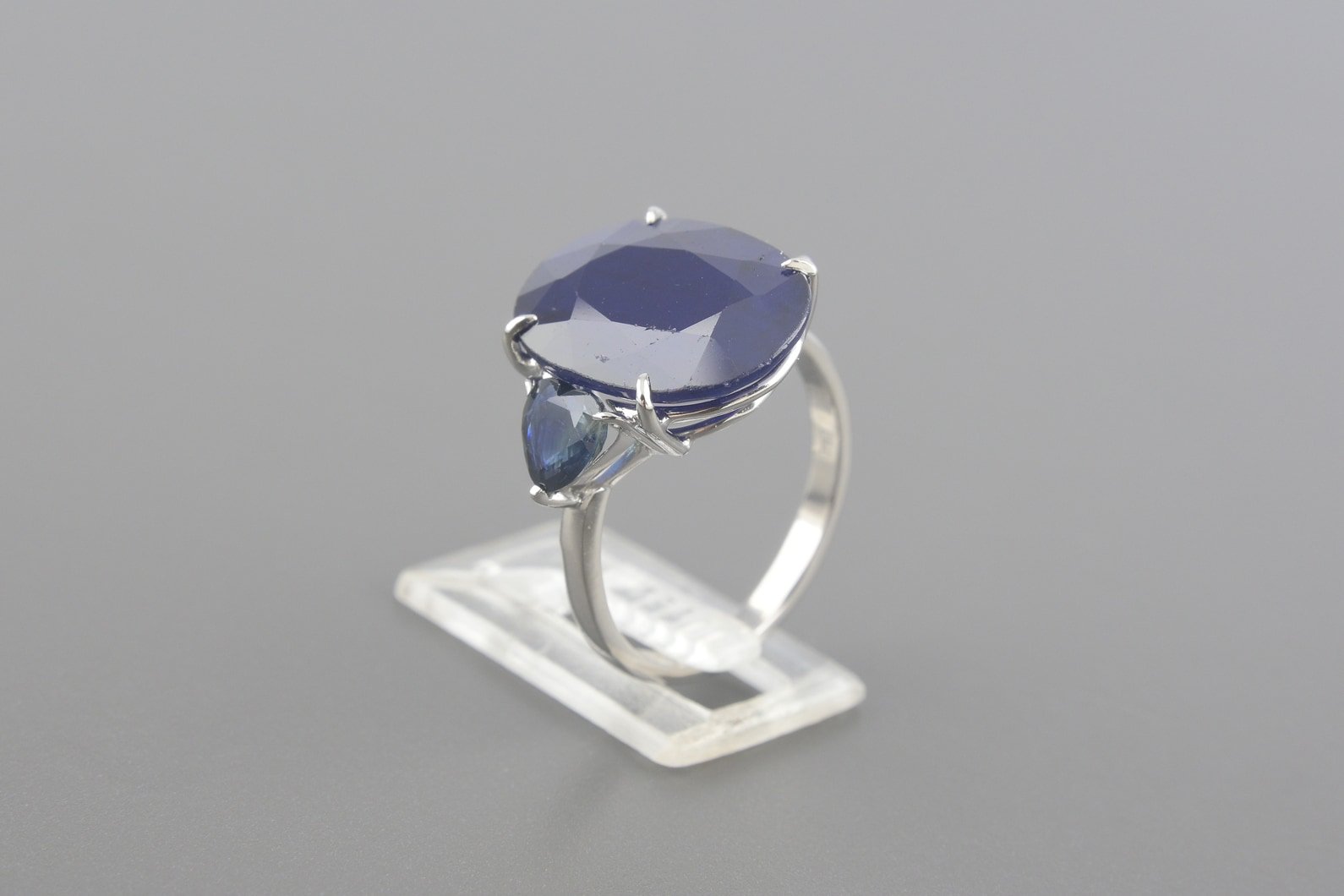 Anel em Ouro Branco 18k com Safira de 16x12mm e Topázios London Lap. Coração de 6x5mm