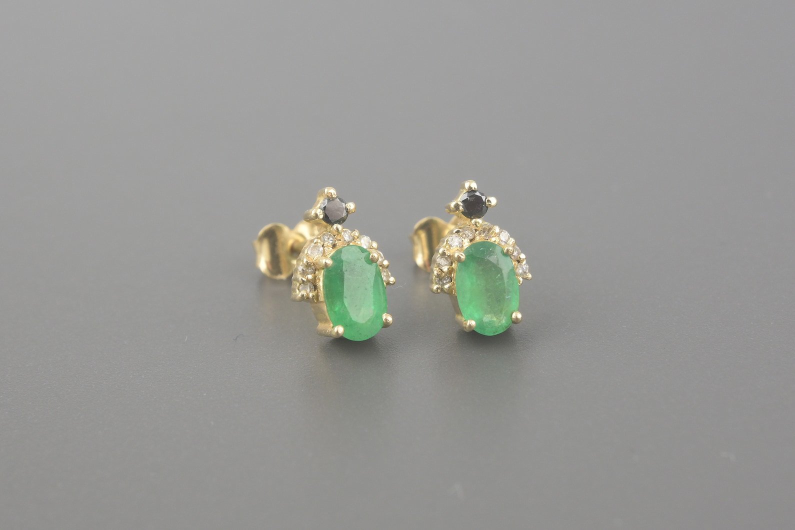 Brincos em Ouro Amarelo 18k com Esmeraldas de 6x4mm, Aprox. 6pts de Diamantes Negros e Aprox. 8pts de Brilhantes