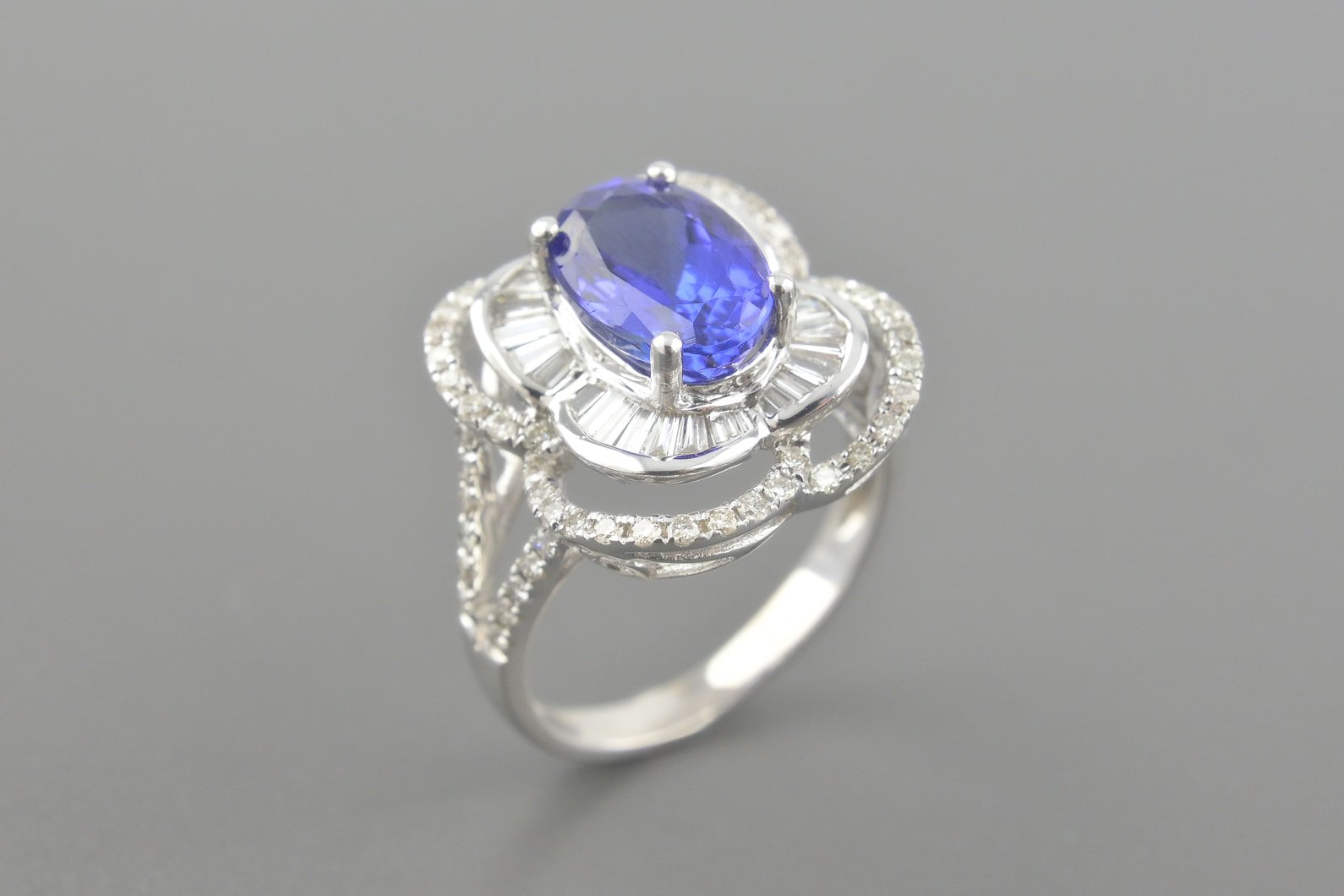 Anel em Ouro Branco 18k com Tanzanita de Aprox. 2.61ct (10x7mm) e Diamantes Trapézio e Brilhante