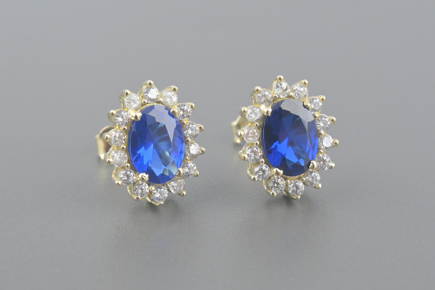 Brincos em Ouro Amarelo 18k com Zirconia Azul de 7x5mm e Zirconias Brancas de 1mm