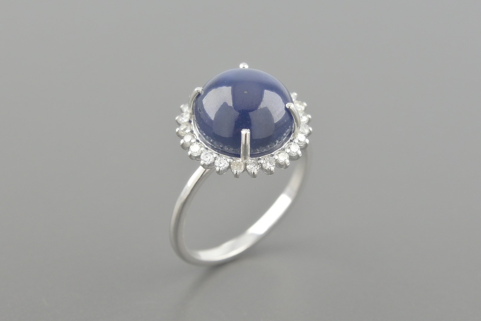 Anel em Ouro Branco 18k com Safira Cabochon de 10.6mm e Aprox. 25pts de Brilhantes