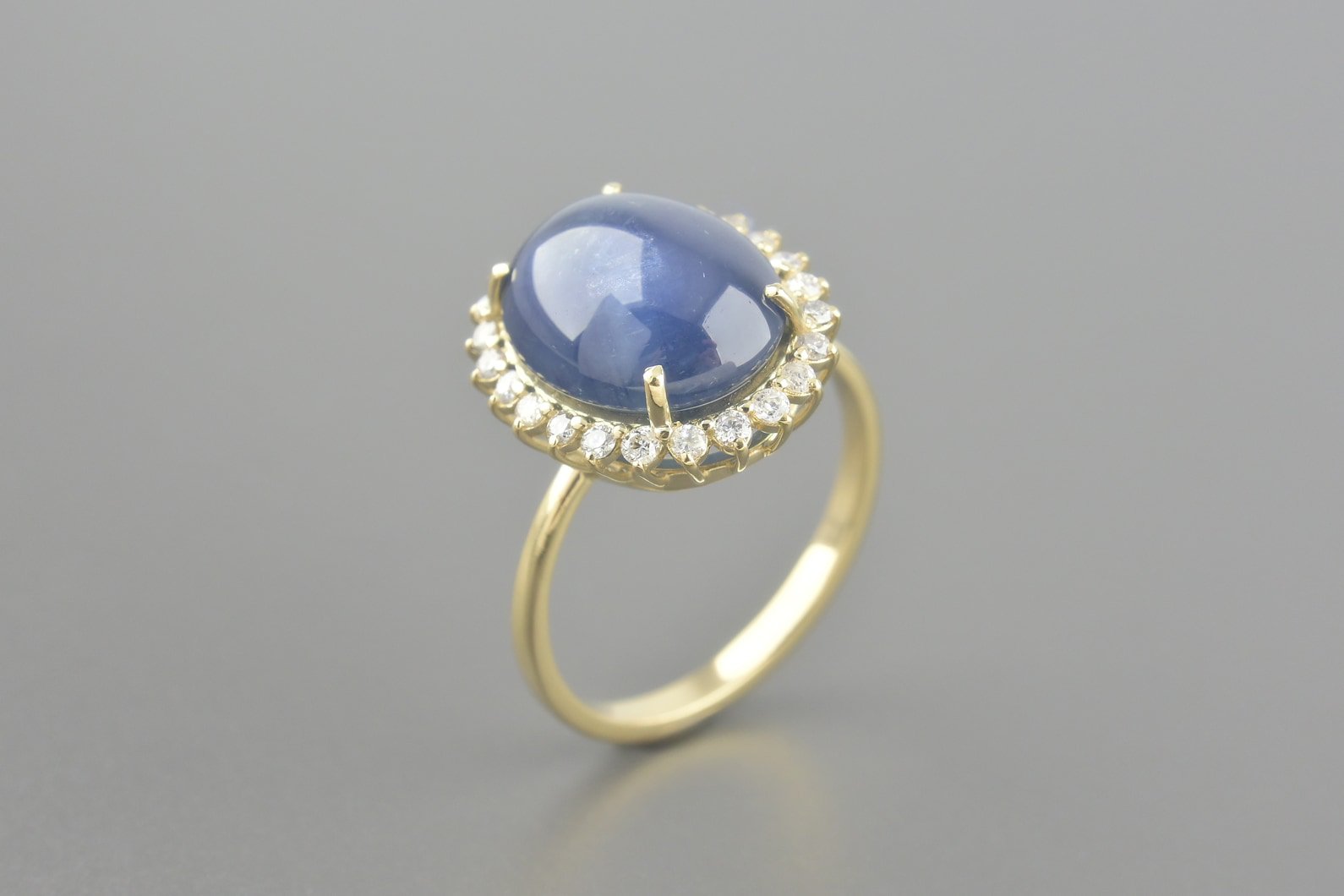 Anel em Ouro Amarelo 18k com Safira Cabochon de 13x10.5mm e Aprox. 24pts de Brilhantes