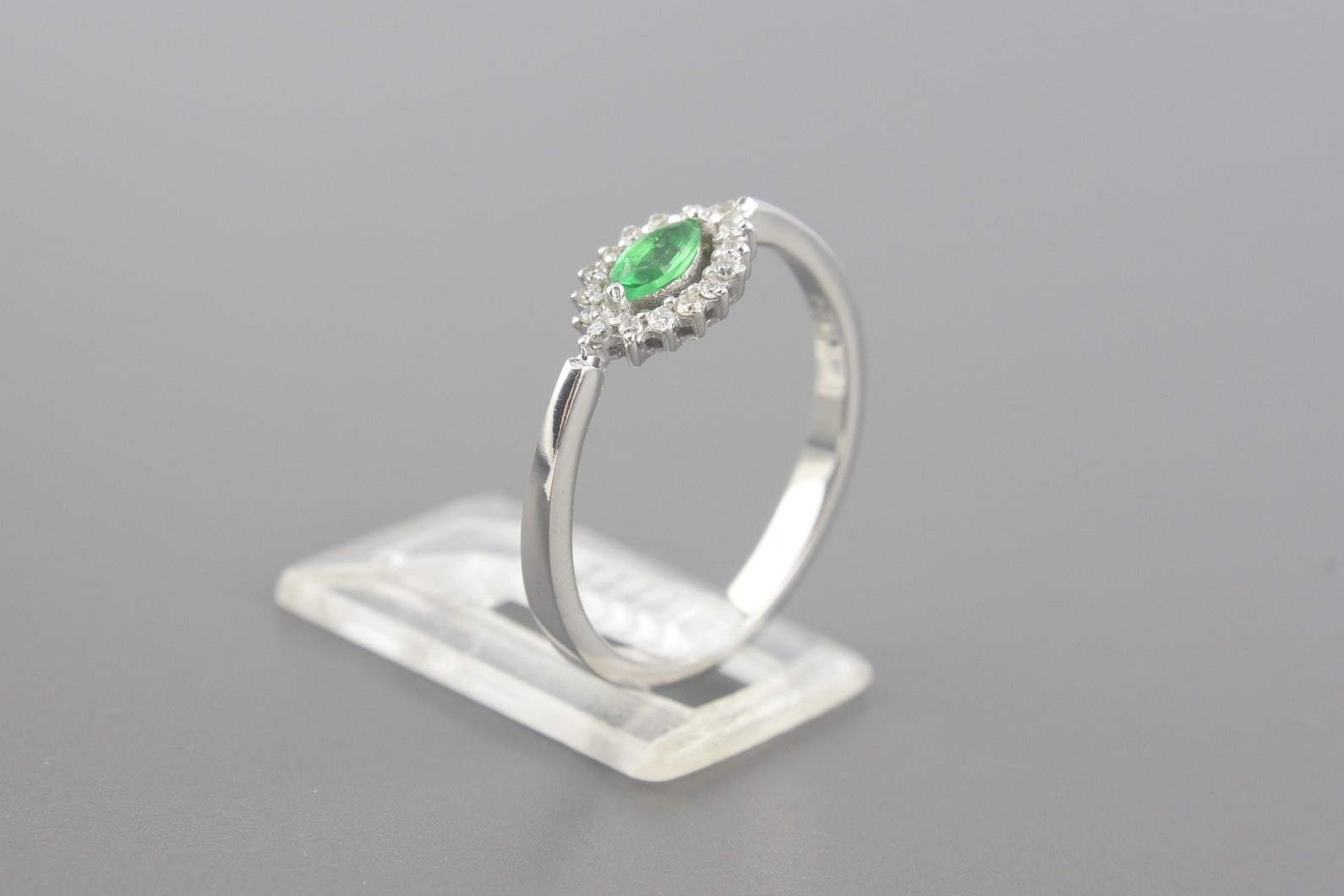 Anel Solitário em Ouro Branco 18k com Esmeralda de 4.5x2.5mm e Aprox. 8pts de Brilhantes