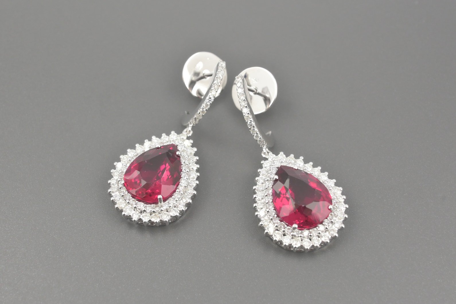 Brincos em Ouro Branco 18k com Turmalinas Vermelhas Lap. Gota de 13.5x10.0mm e Aprox. 1.34ct de Brilhantes
