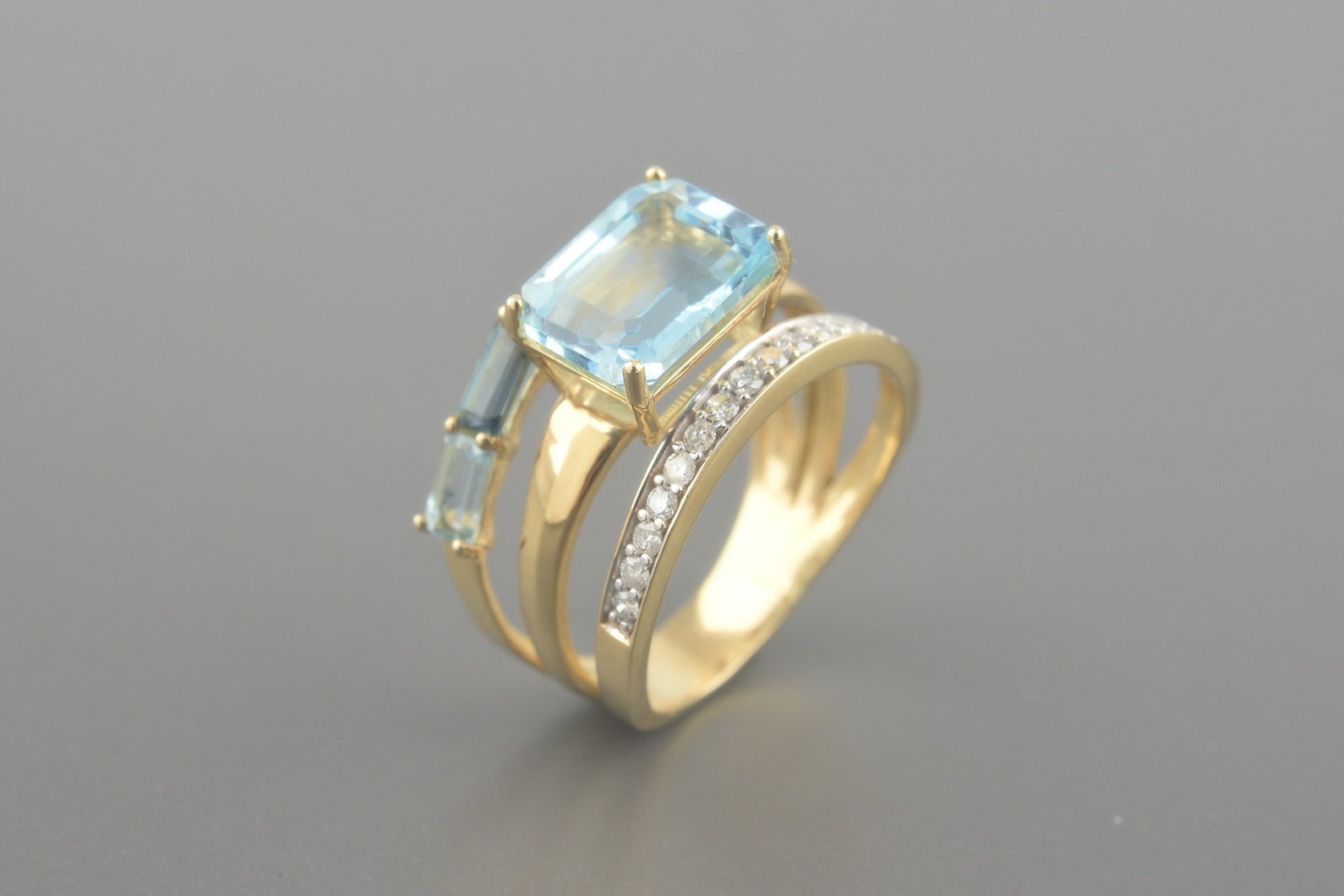 Anel em Ouro Amarelo 18k com Topázios Azuis e London (Central de 10x8mm) e Aprox. 15pts de Brilhantes